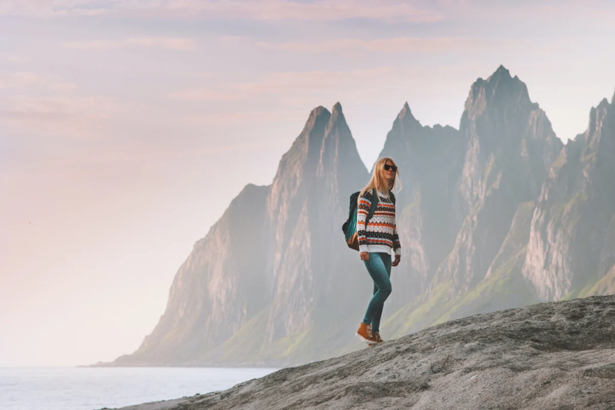Tourist woman traveling in Norway active lifestyle vacations outdoor Okshornan peaks landscape Senja island