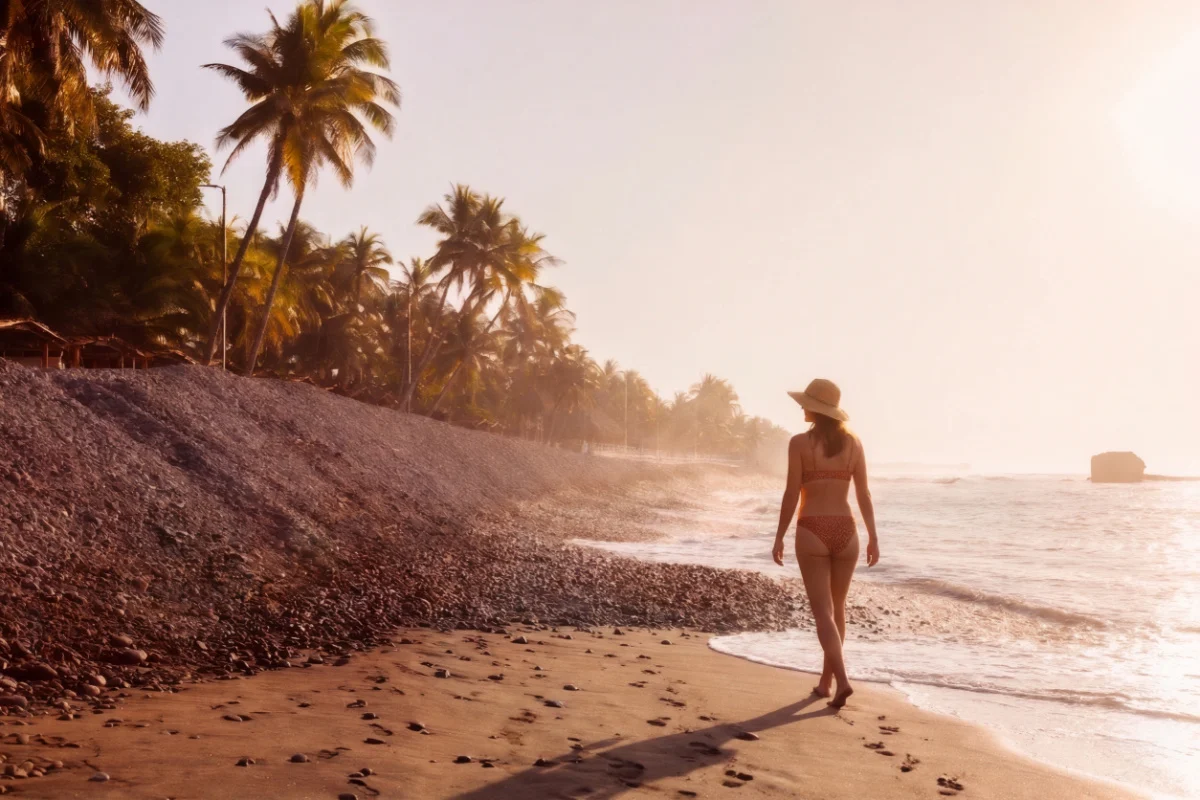Woman walking along the beach in El Tunco, El Salvador