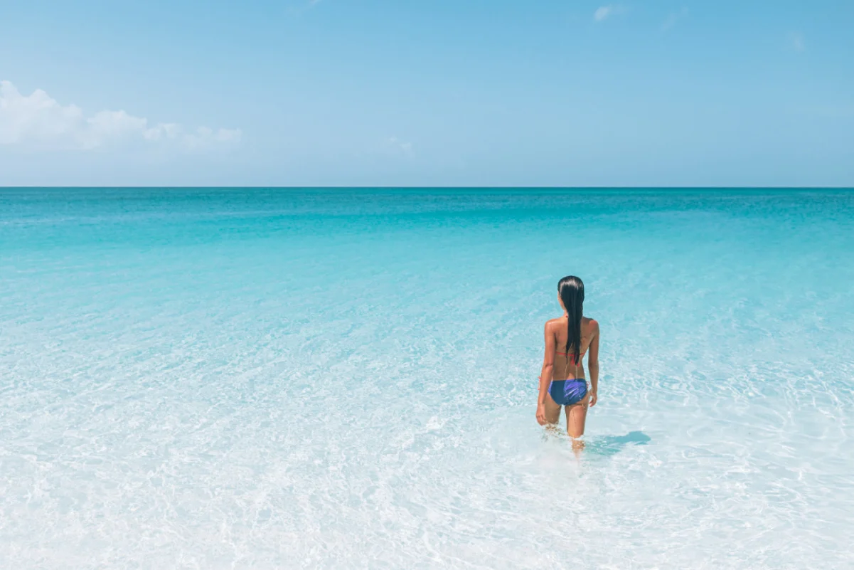 Woman walking into the ocean in South Caicos